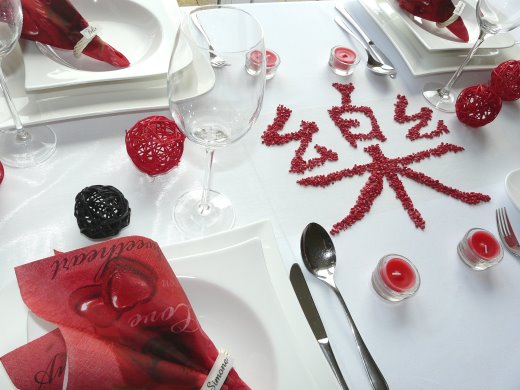 Tischdeko-online mit dem roten Mustertisch Asia. Tisch 3. Bild 2., Rote Kerzen,  Kuwa-Stöckchen, rote und schwarze Rattankugel, Streudeko. Alles für Ihre Hochzeit als Tischdekoration oder die private Feier.